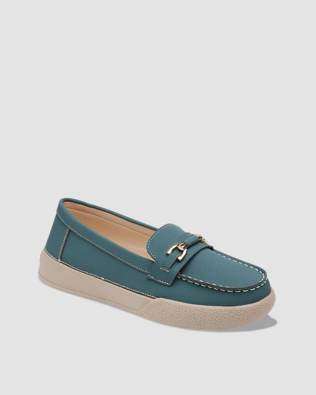 Teal slip-on loafers with a gold buckle and a chunky white sole.