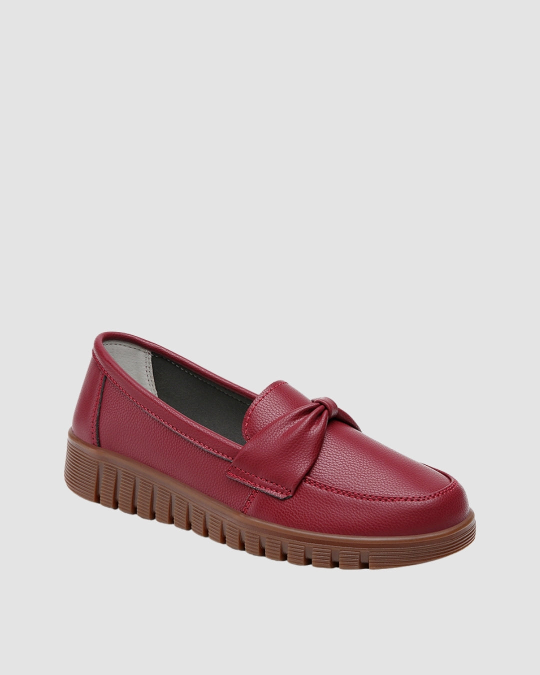 Red loafer shoes with a bow detail and a chunky sole.